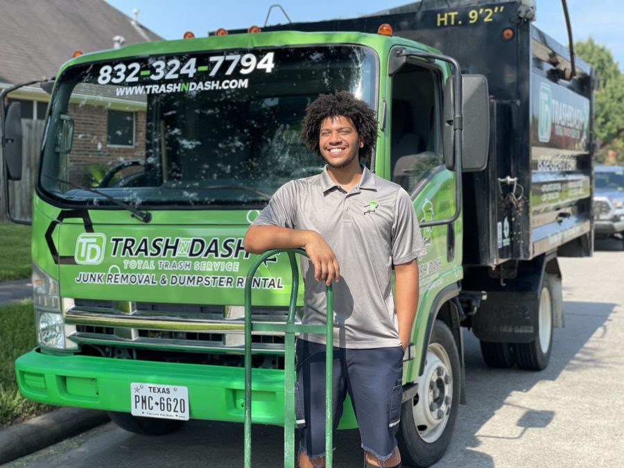 junk pro smiling in front of junk removal truck